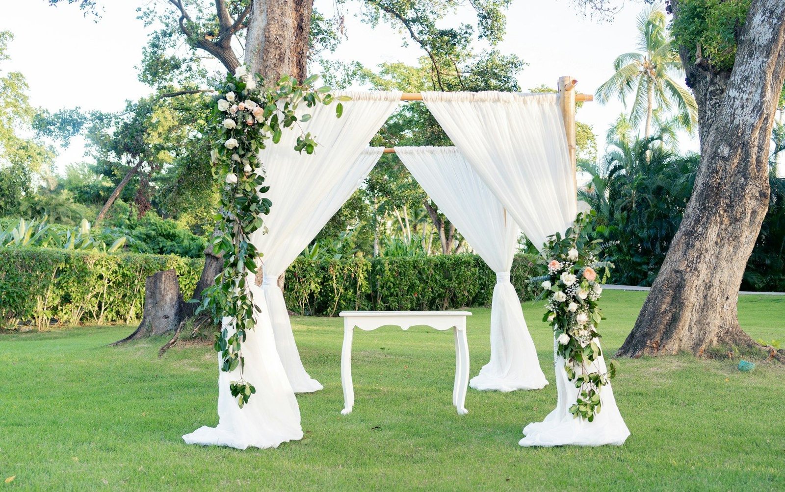 Outdoor wedding ceremony with white drapes and flowers